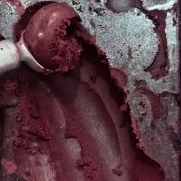 Açaí no copo com granola, leite condensado e frutas.